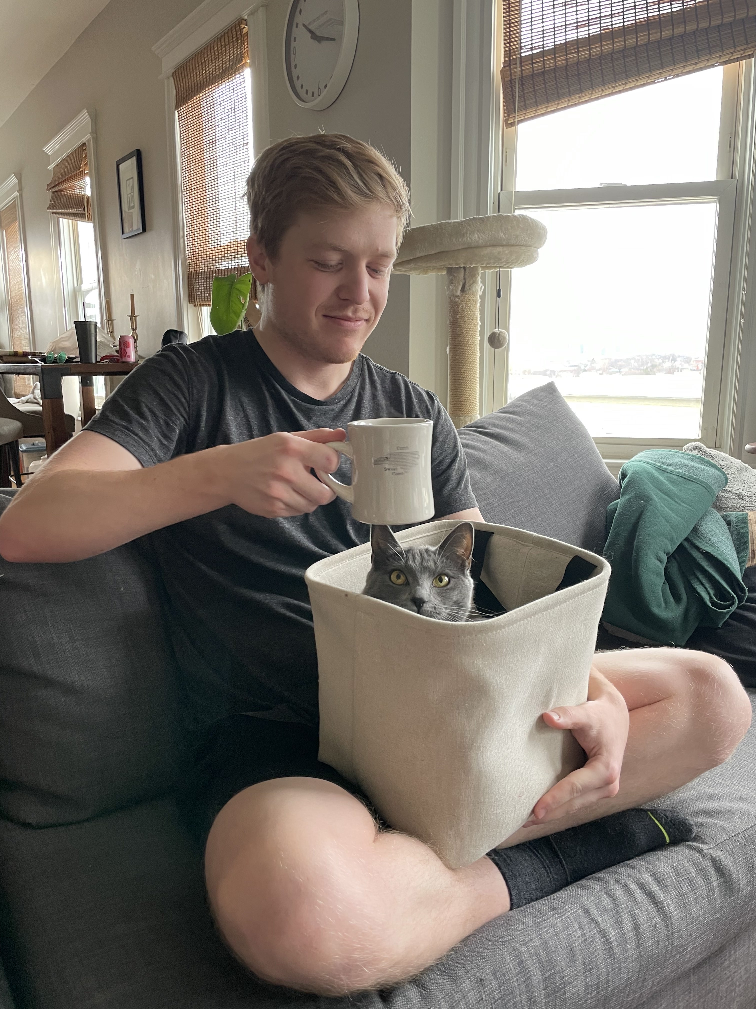 A picture of me holding a cat and a mug of coffee